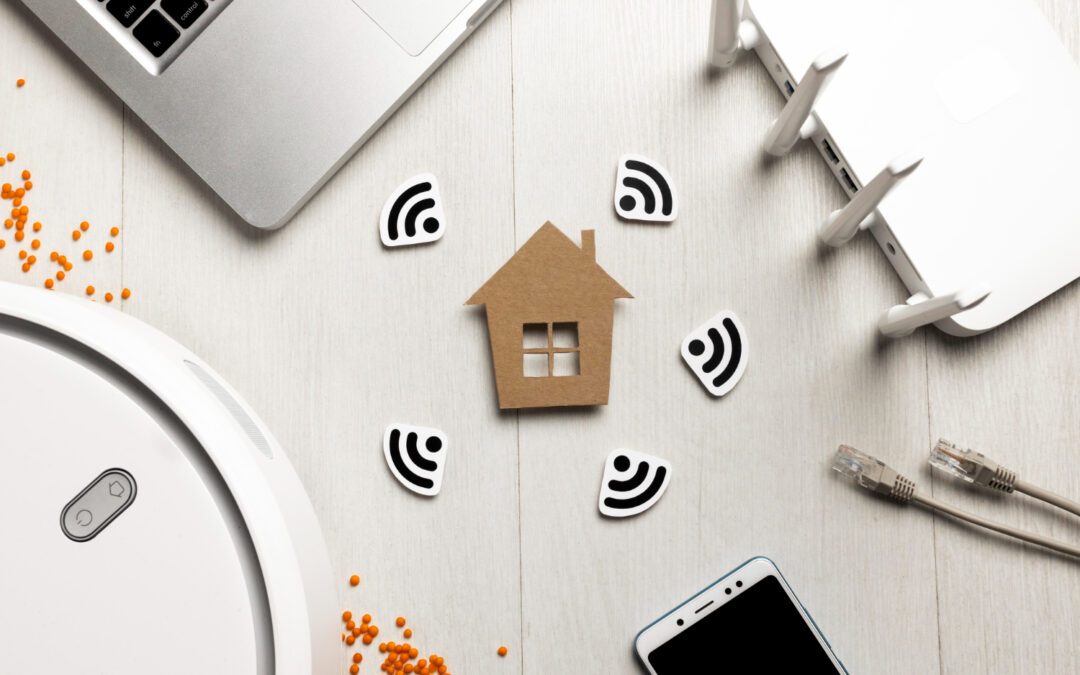 Cardboard house surrounded by wifi symbols with a laptop, robot vacuum cleaner, cell phone and router